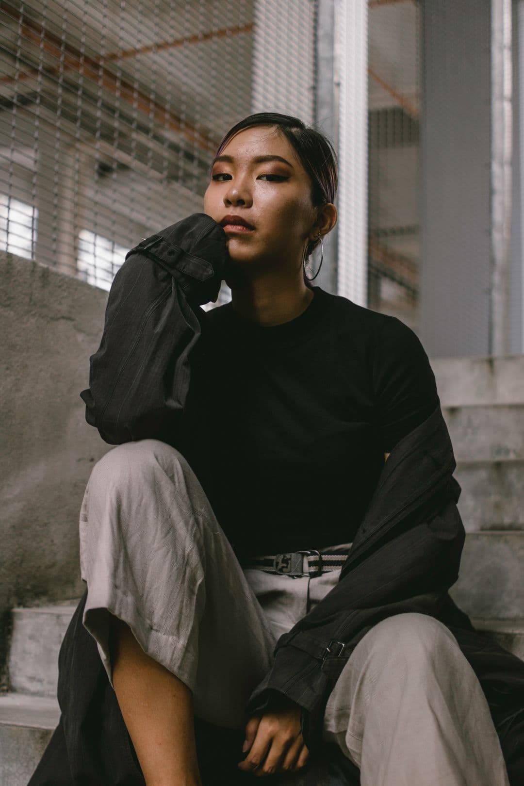 Portrait of a client in a dark jacket, resting her chin on her hand.